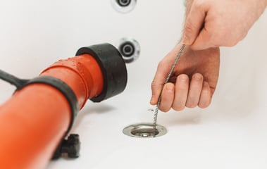 Someone snaking tub drain